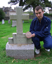 Irish First World War Researcher Conor Dodd at the grave of Canadian Soldier Sergeant Gavin Francis Andrew.  He is holding Gavin Andrew’s commemorative plaque.